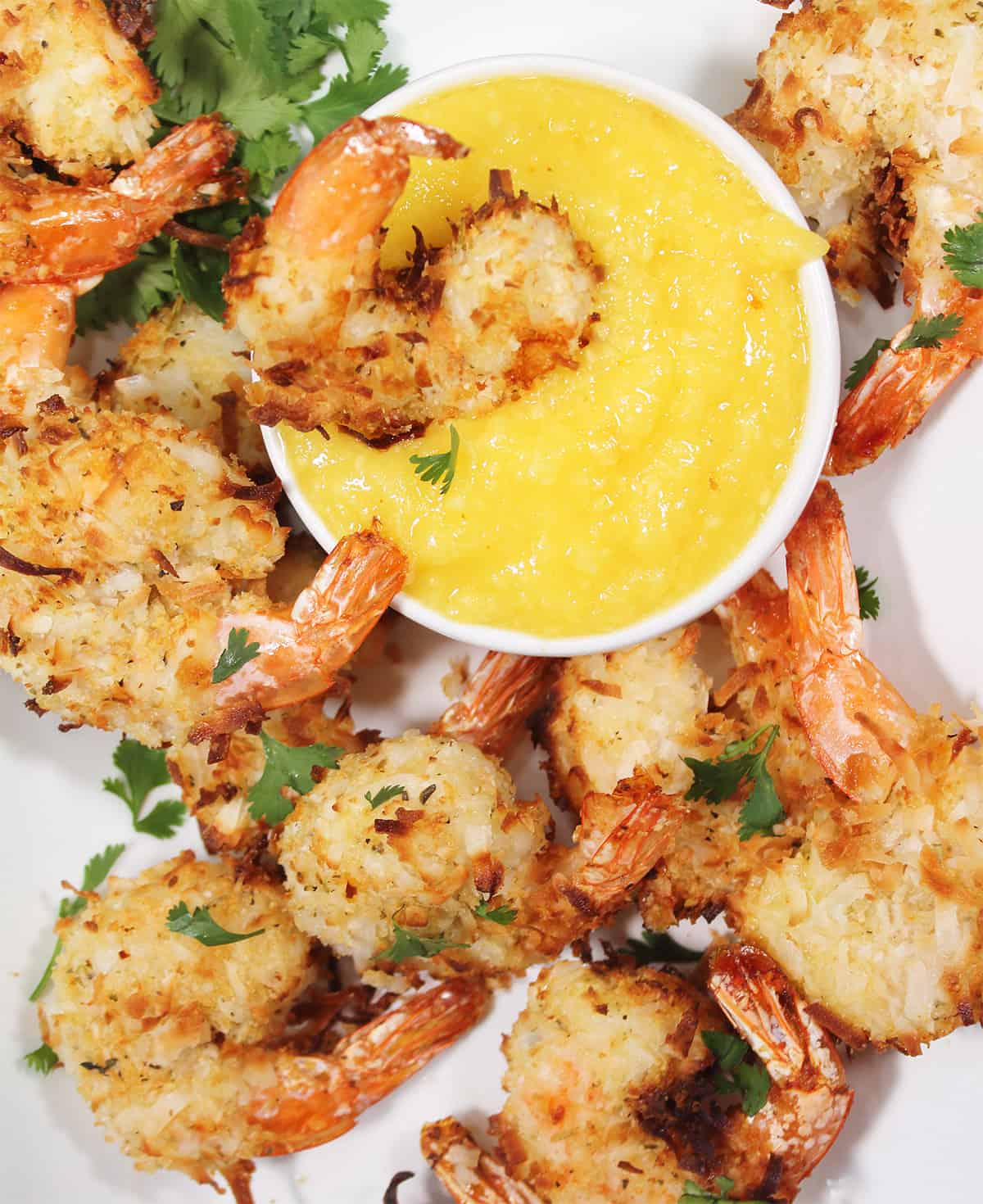 air fryer crispy coconut shrimp with mango salsa — tropical & crunchy seafood delightshrimp in dipping sauce surrounded by other shrimp